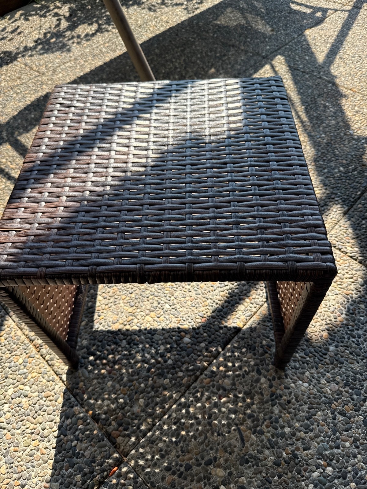 Brown rattan chair, black glass table top, blue seat cushion