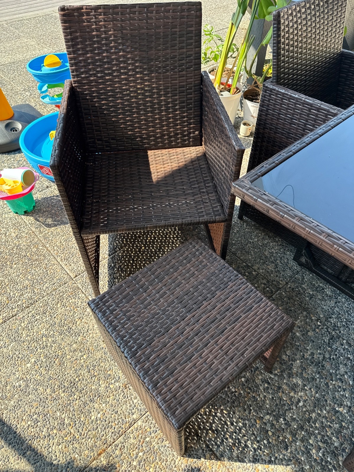 Brown rattan chair, black glass table top, blue seat cushion
