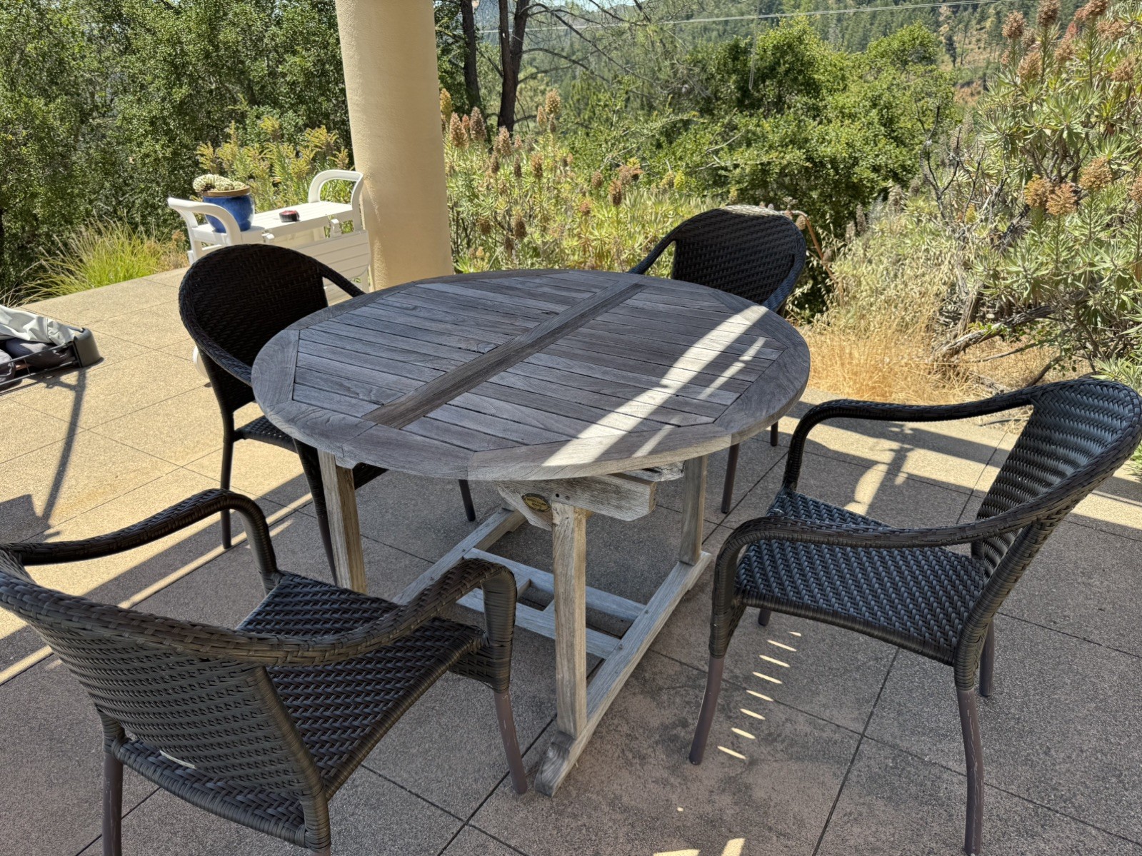 Teak dining table and 4 chairs (67″x47″); center leaf folds under to a 48” round
