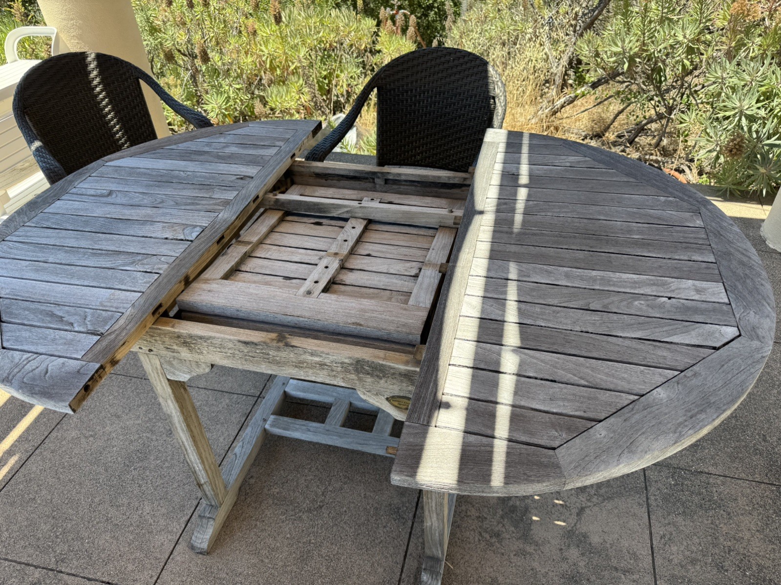 Teak dining table and 4 chairs (67″x47″); center leaf folds under to a 48” round