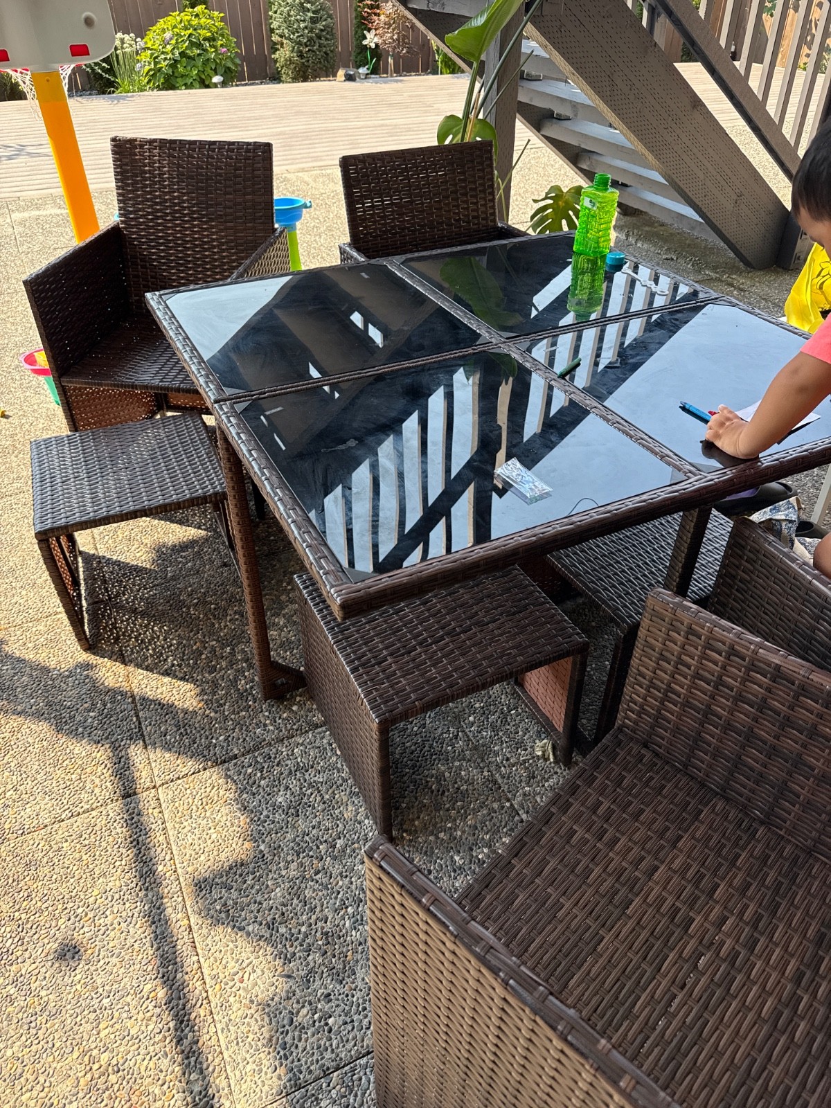 Brown rattan chair, black glass table top, blue seat cushion